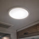 Ceiling light fixture on a white ceiling with wooden cabinets below