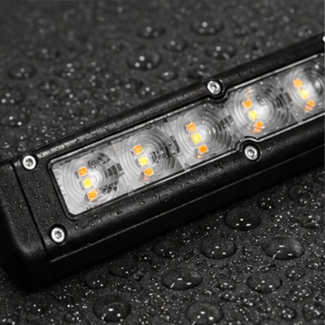 LED light bar on a textured black surface with water droplets