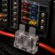 Close-up of a fuse box with colored fuses and connected wires.