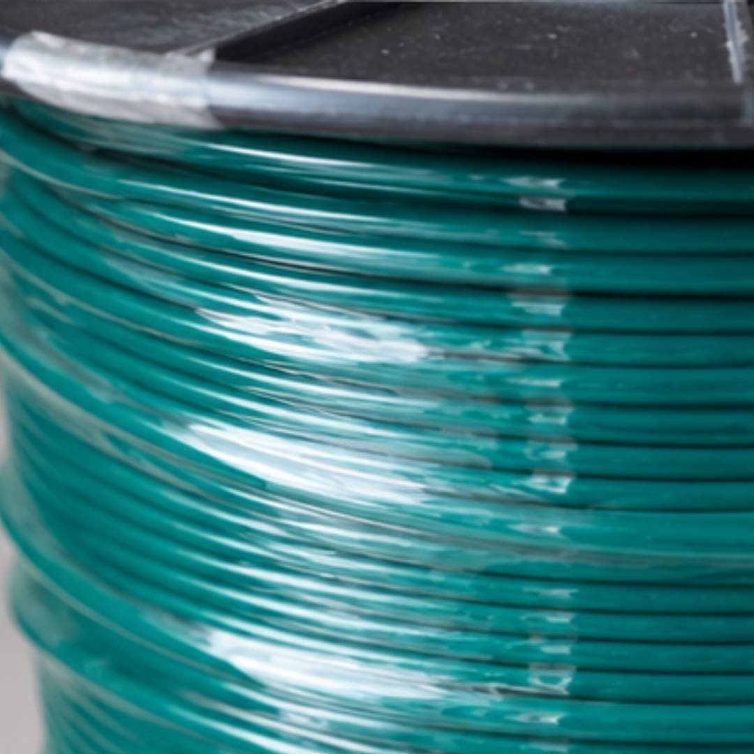 Close-up of a roll of green wire on a black background