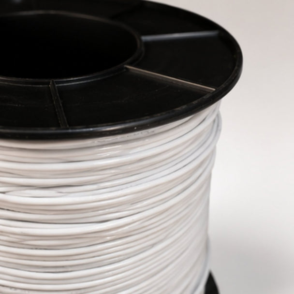 Spool of white cable with black top on a light gray background