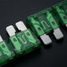 Row of green automotive fuses on a black background