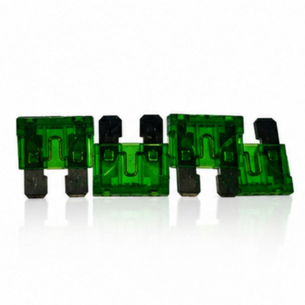 Five green automotive fuses on a white background