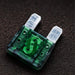 Green automotive fuse on a dark textured background