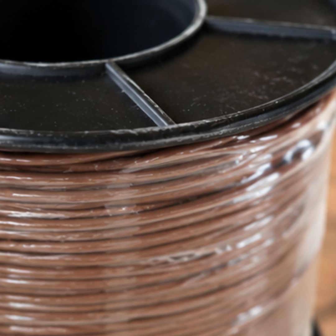 Close-up of a spool of brown wire with a black lid.