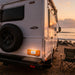 White RV parked on a sandy beach with a sunset in the background with fitting Amber LED Side Marker & Reflector on the back of the caravan