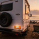 White RV parked on a sandy beach with a sunset in the background with fitting Amber LED Side Marker & Reflector on the back of the caravan