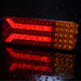 Red and orange LED light on a dark surface with water droplets.