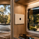 Close-up of a wooden panel inside a vehicle with a window and electronic devices on a table.