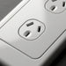 Close-up of a white electrical outlet on a gray background