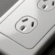 Close-up of a white electrical outlet on a gray background