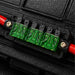 Close-up of a black electrical connector with green and red terminals.