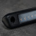 Close-up of a black electronic device with a textured surface on a dark background