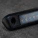 Close-up of a black electronic device with a textured surface on a dark background