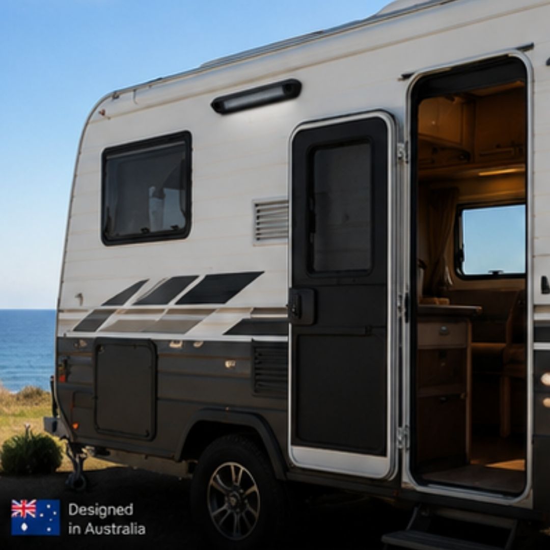 Small trailer with open door, designed in Australia, near a body of water.