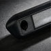 Close-up of a textured black object on a dark surface