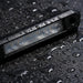Black phone case with water droplets on a wet surface
