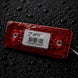 Red reflective label with a barcode on a dark textured background
