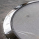 Close-up of a metal strainer with a textured surface on a gray background