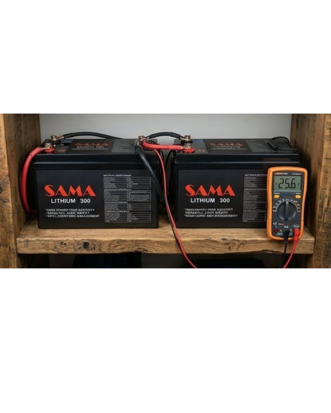 Two SAMA lithium batteries on a wooden shelf with a multimeter displaying voltage.
