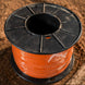 Spool of orange cable on a wooden surface