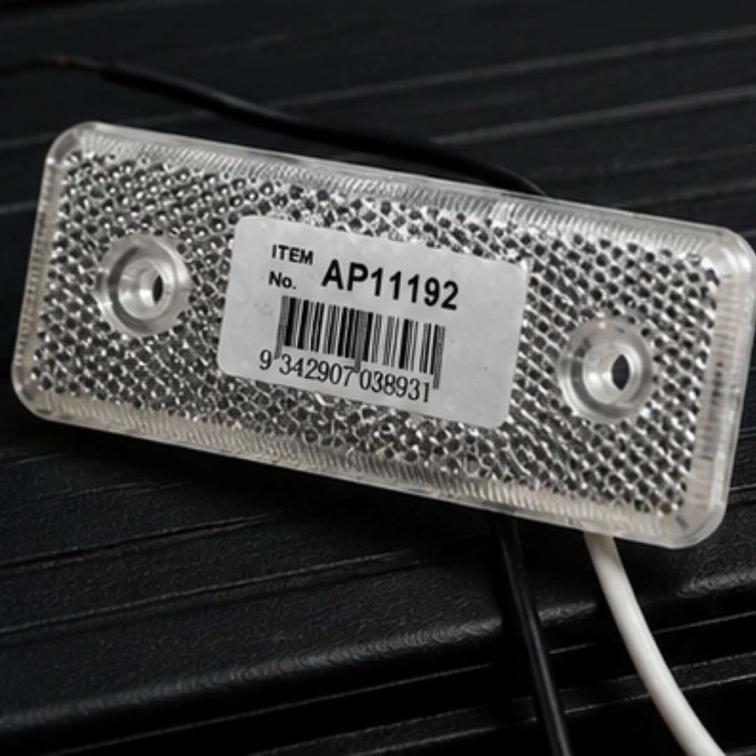 Red reflective label with a barcode and item number on a dark surface