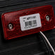 Red reflective label with barcode and text on a dark background